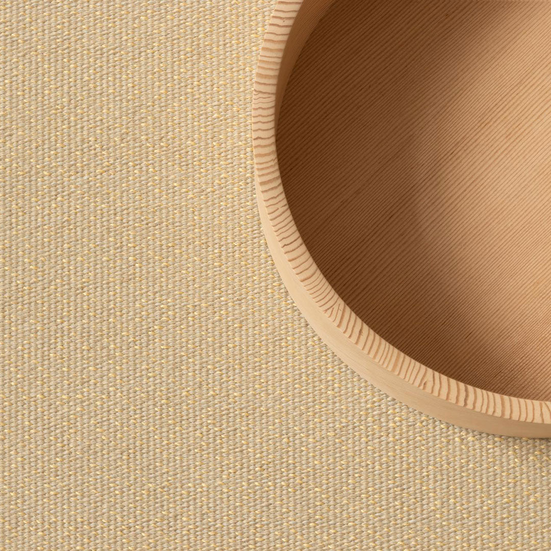 Textured beige fabric with subtle golden threads, complemented by a smooth, light wood circular edge.