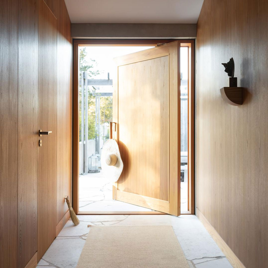 Bright wooden entrance with a light-colored doorway and minimalist decor, featuring warm tones and soft textures.
