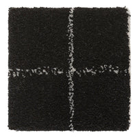 Black textured square rug with white cross pattern, perfect for adding a modern touch to any space.