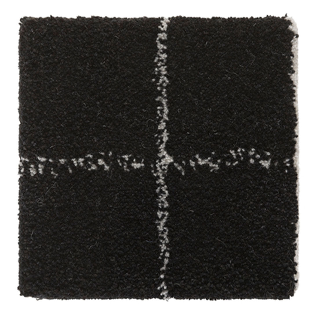 Textured black square rug with contrasting white cross pattern, ideal for modern decor.