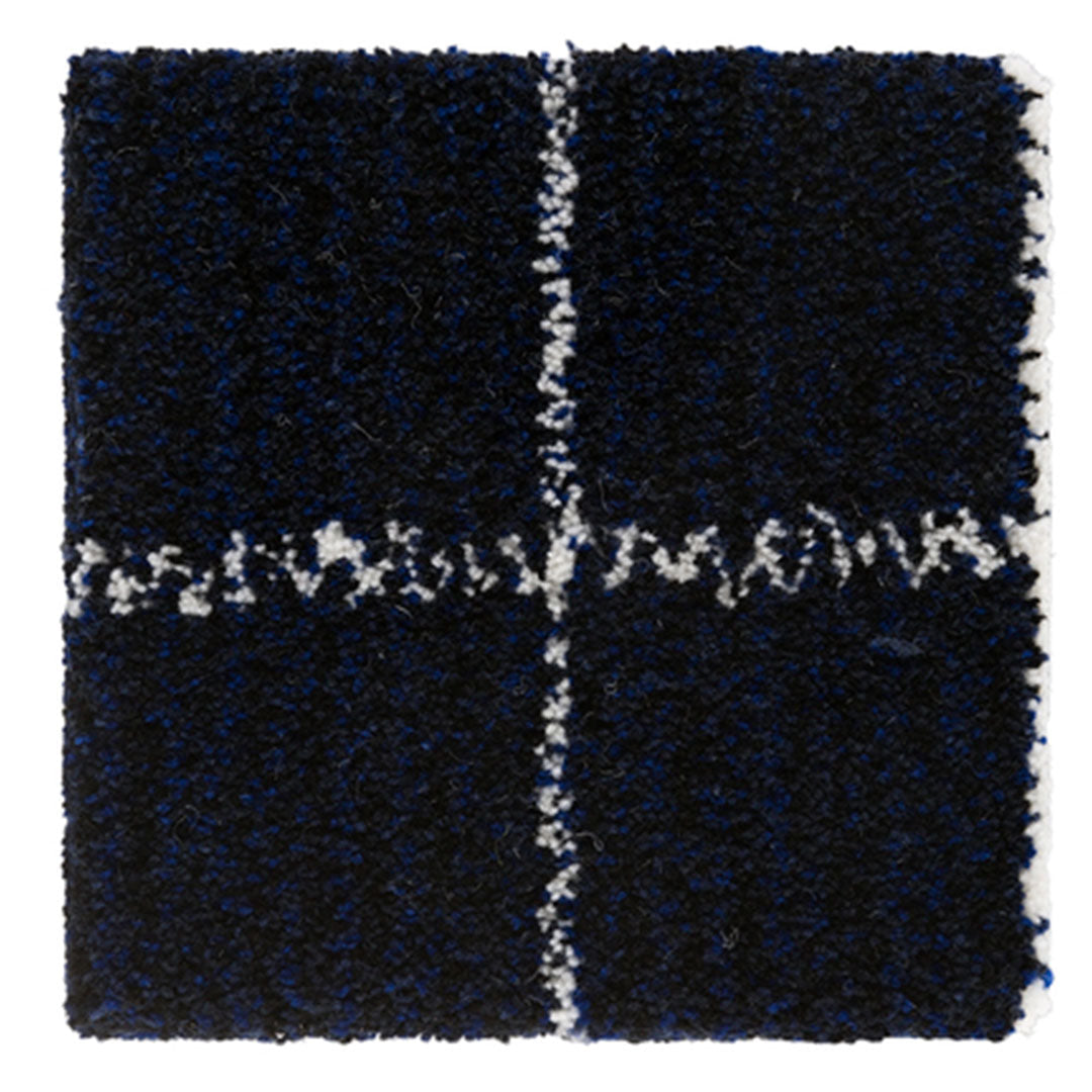 Navy blue rug with white abstract pattern, featuring a textured, fluffy surface and a grid design.
