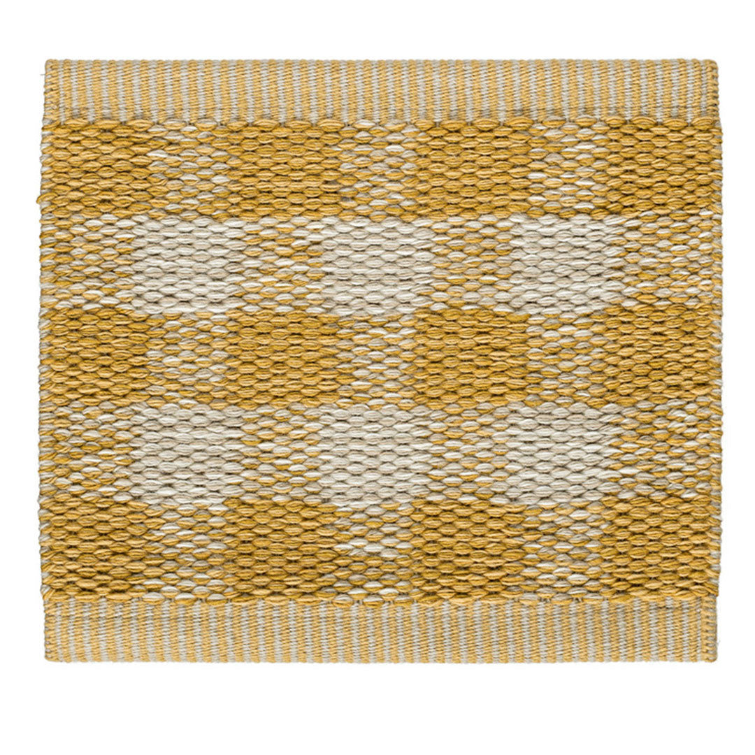 Yellow and cream patterned rug with a textured, woven design. Perfect for adding warmth to any space.