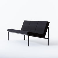 Black minimalist sofa with geometric pattern and sleek metal frame, perfect for modern living spaces.
