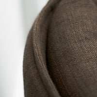 Brown textured fabric with a subtle weave pattern, adding depth and warmth to home decor.