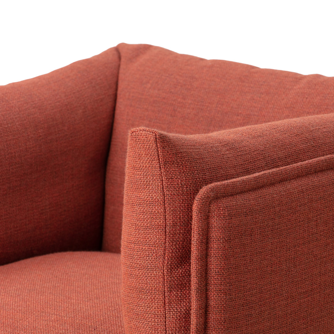 Rust-colored fabric armchair with a smooth, textured pattern, showcasing modern design and cozy elegance.