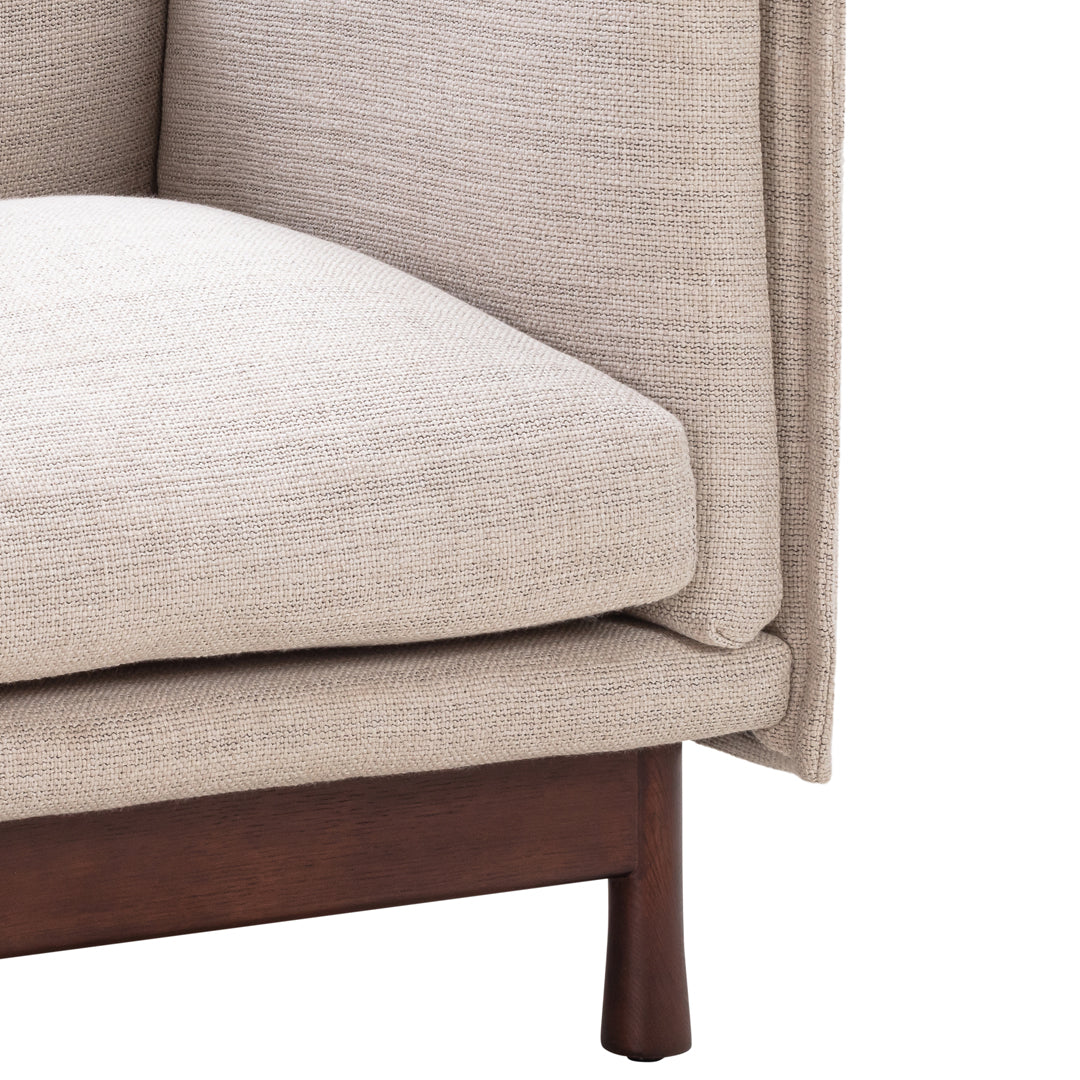 Beige textured fabric upholstery with subtle pattern on a wooden sofa base.