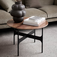 Round wooden coffee table with a rich walnut finish, black geometric metal base, and modern styling.