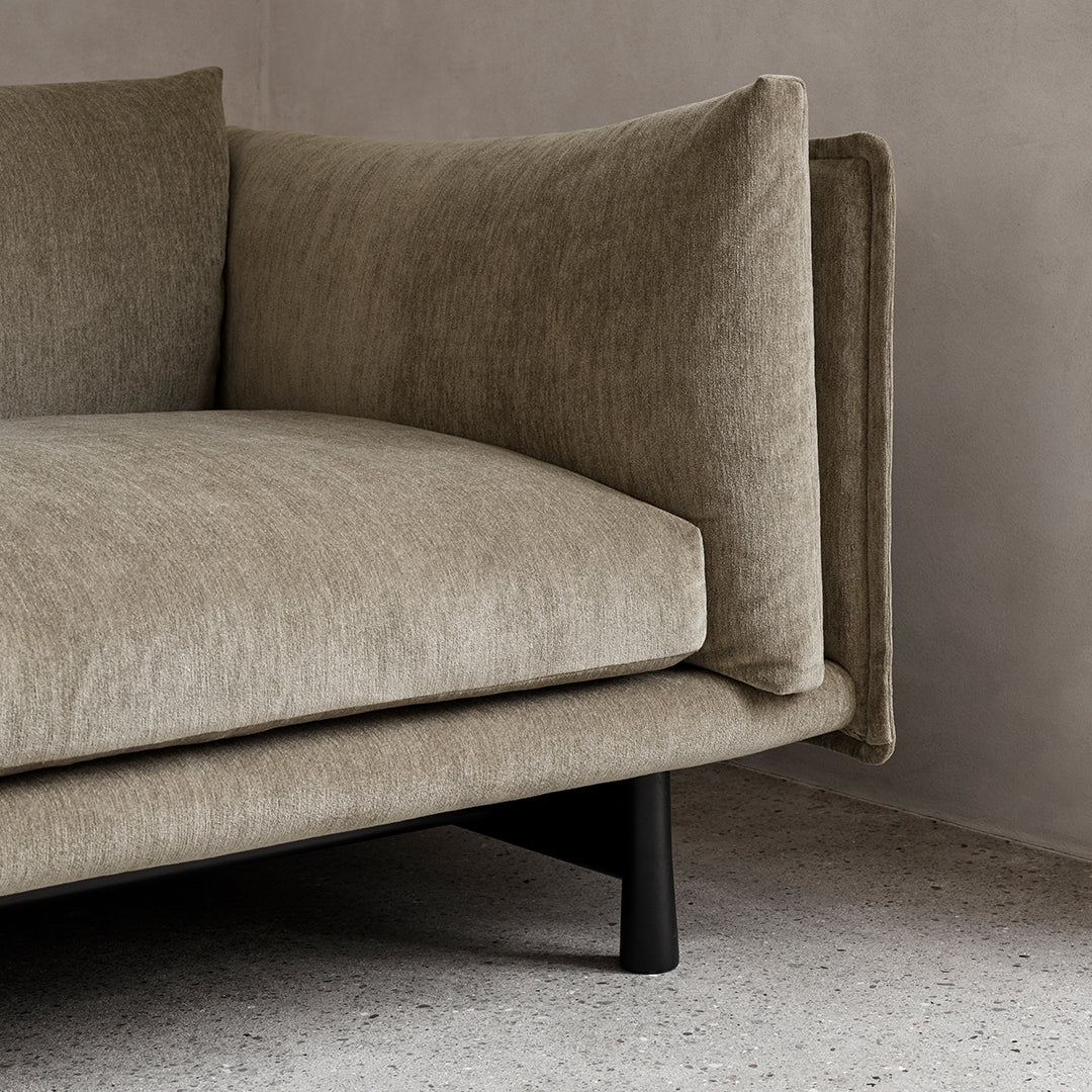 Soft beige fabric with subtle texture and plush cushions, complemented by sleek black legs. Modern and stylish design.