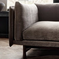 Grey upholstered sofa with a smooth texture and minimalist design, featuring a natural wood base.