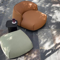 Brown and green plush seating with textured fabric, set against a dark stone surface. Modern and inviting pattern.
