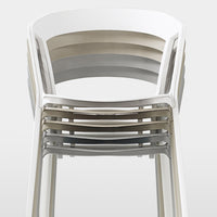 Stacked chairs in soft shades of white, gray, and beige create a minimalist, modern look with smooth, curved lines.