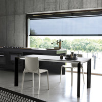 Modern black and white dining table and chair set with sleek lines in a minimalist environment and natural light.