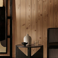 Minimalist table with black and natural wood tones; features white and black decorative accents. Elegant modern design.