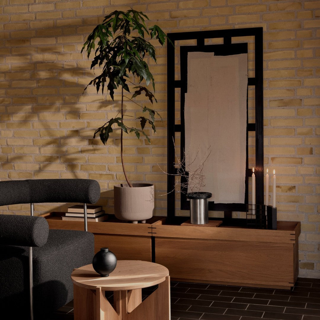 Modern living room with earthy tones, black accents, and subtle geometric patterns in furniture and decor.