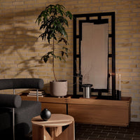 Modern living room with earthy tones, black accents, and subtle geometric patterns in furniture and decor.