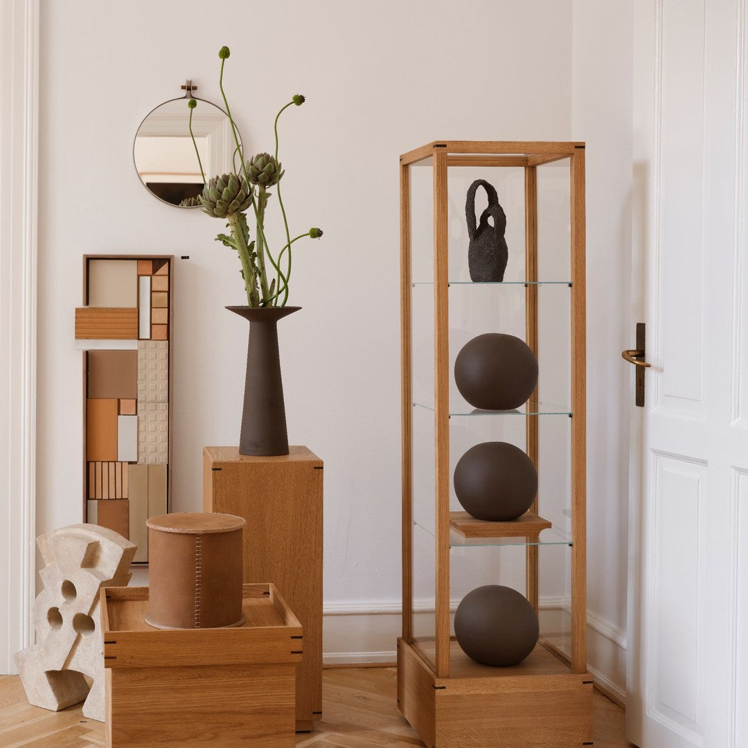 "Natural wood furniture with earth-toned decor; geometric shapes and smooth textures create a warm, modern aesthetic."