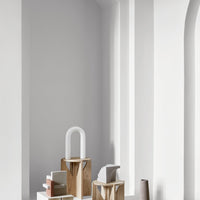 Minimalist decor showcasing neutral tones, wooden textures, and geometric shapes against a soft white backdrop.