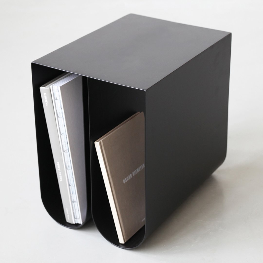 Modern black minimalist bookend with smooth, curved design, showcasing a sleek finish and simple geometric patterns.
