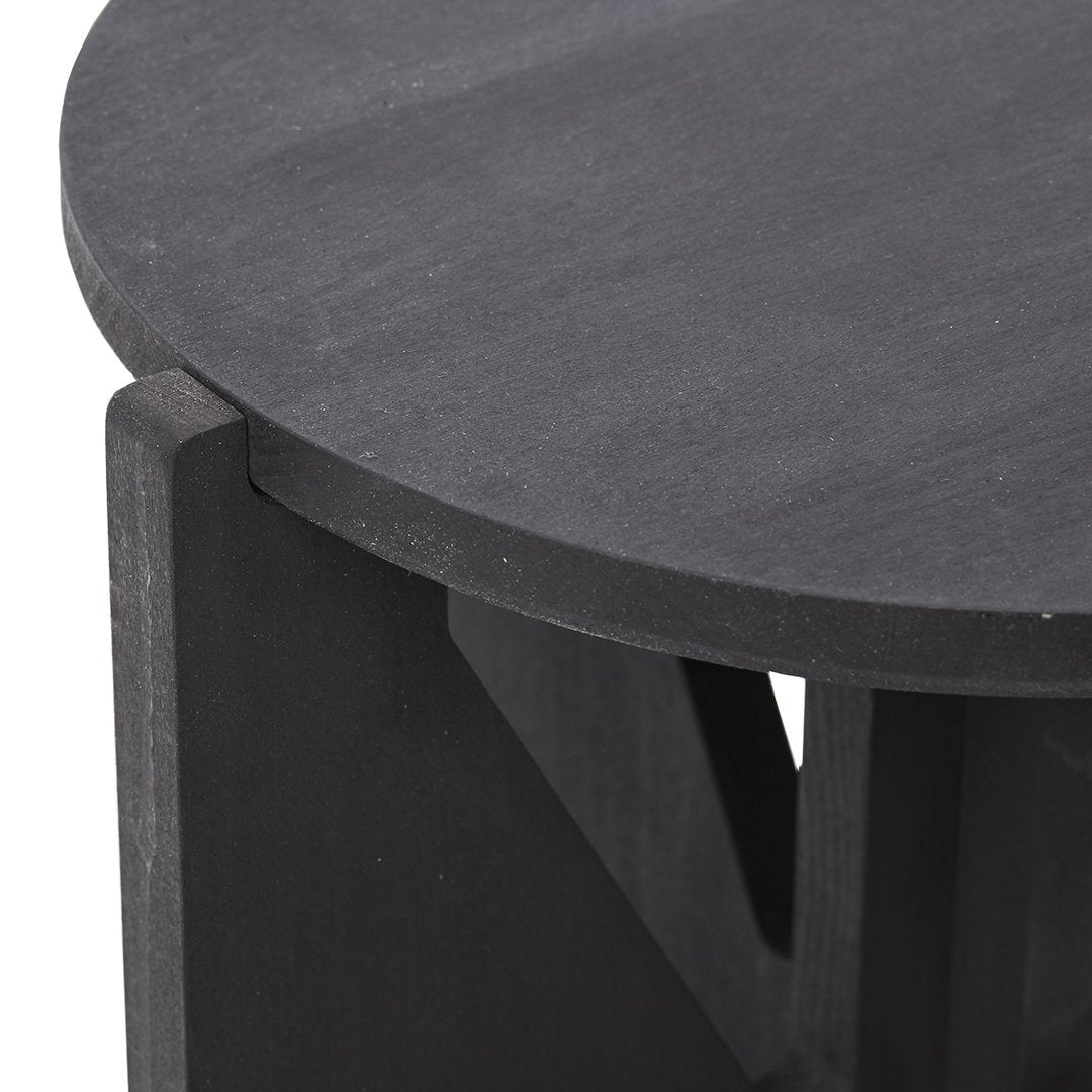 Black round wooden table with a smooth finish and angular details, showcasing a modern minimalist design.