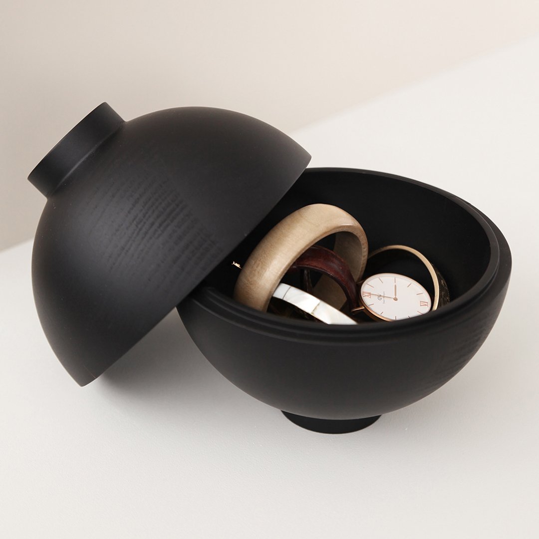 Black ceramic bowl with a matte finish, featuring a sleek, round design and subtle textured patterns.
