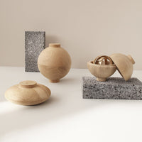 "Natural wood tones with smooth textures and matte gray stone accents in a modern minimalist design."