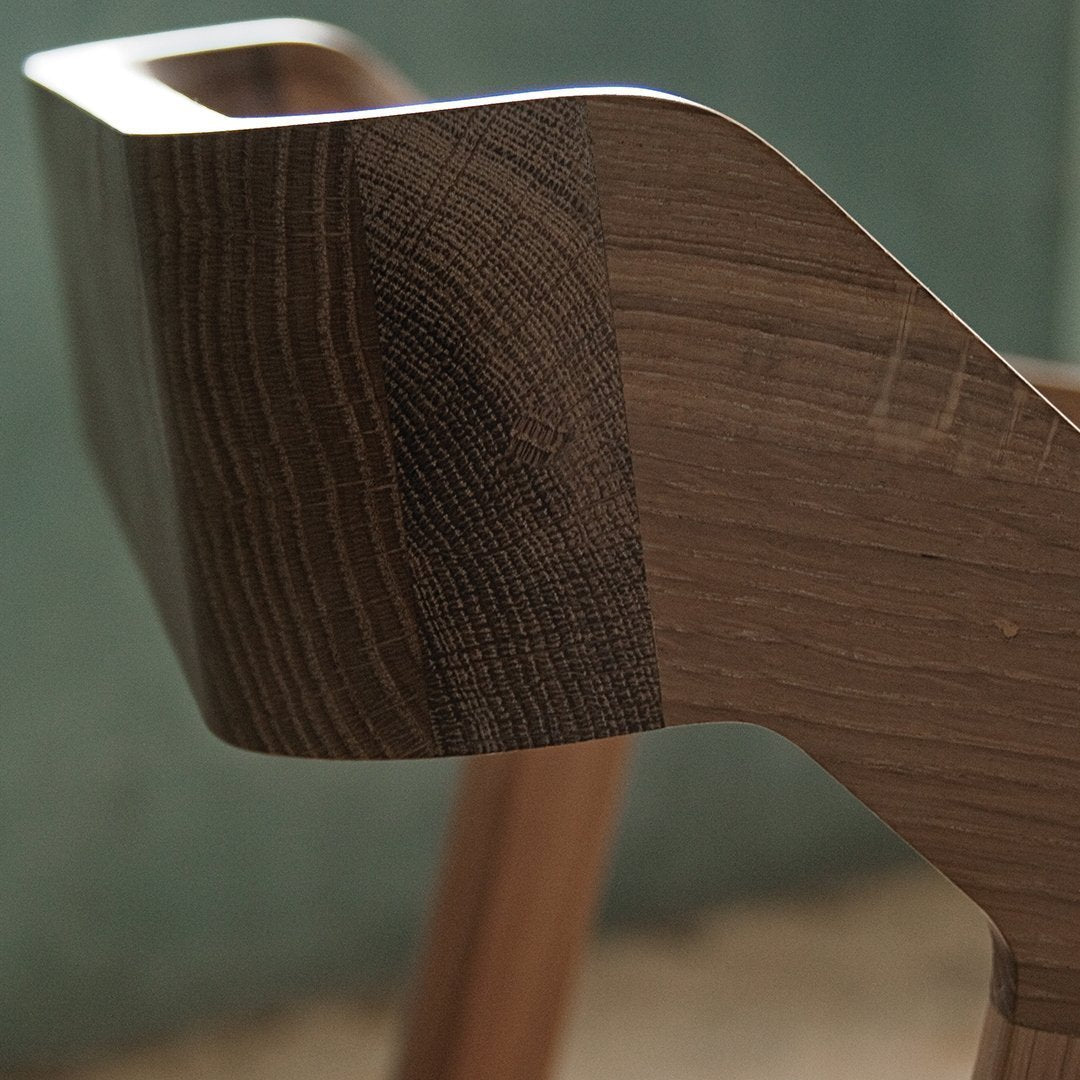 Close-up of a stylish wooden chair showcasing rich brown tones and distinct grain patterns. Perfect for modern decor.