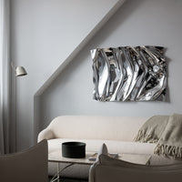Shiny silver abstract wall art with wavy patterns, reflecting light and adding modern elegance to living spaces.