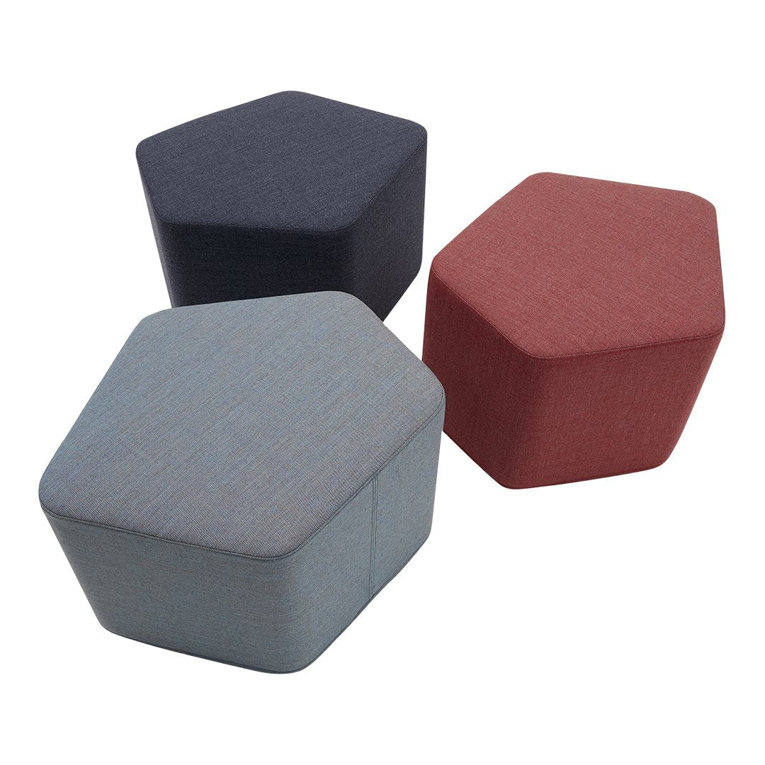 Modern hexagonal fabric stools in navy, light blue, and burgundy, featuring textured patterns.