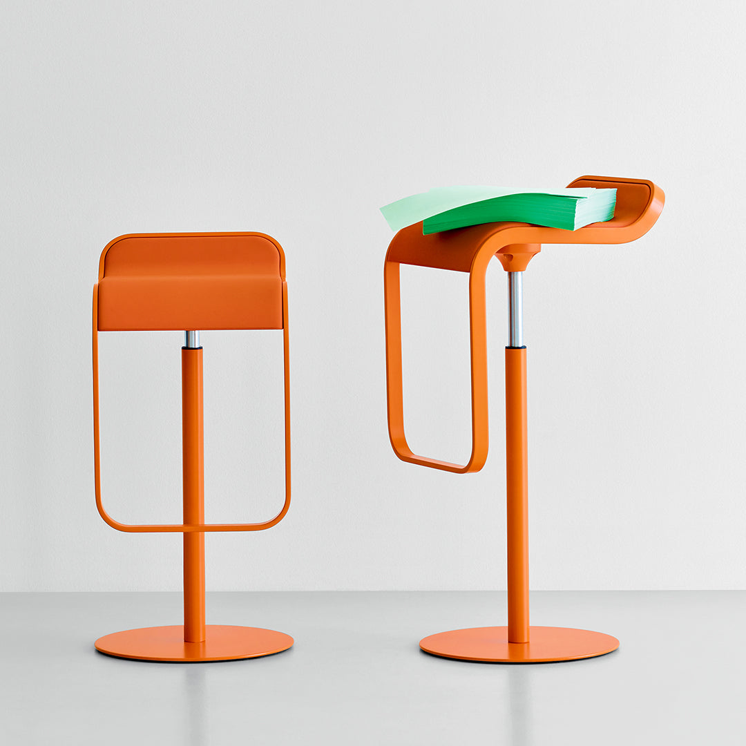 Orange metal bar stools with a sleek design and vibrant green accents, featuring smooth circular bases and curved backs.