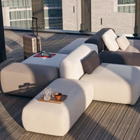 "Modern outdoor seating in light gray and dark gray with soft cushions, featuring sleek, rounded shapes."