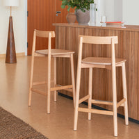 Light wood bar stools with natural finishes paired with a warm wooden countertop and earthy tones in the decor.