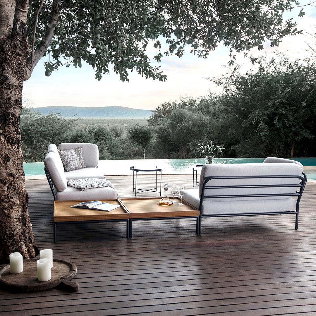 Stylish outdoor seating in gray and white, with wood accents and a sleek metal frame, set against a natural backdrop.