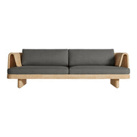 Gray upholstered sofa with natural woven rattan accents and a modern minimalist design, perfect for chic interiors.