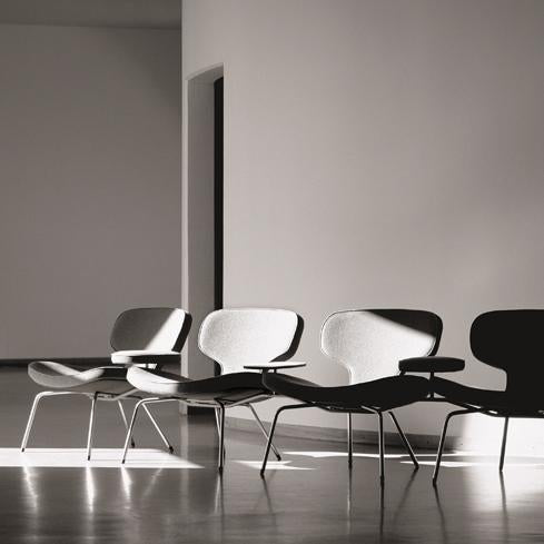 Stylish black and gray chairs with smooth curves and a minimalist design, highlighting light and shadow contrasts.