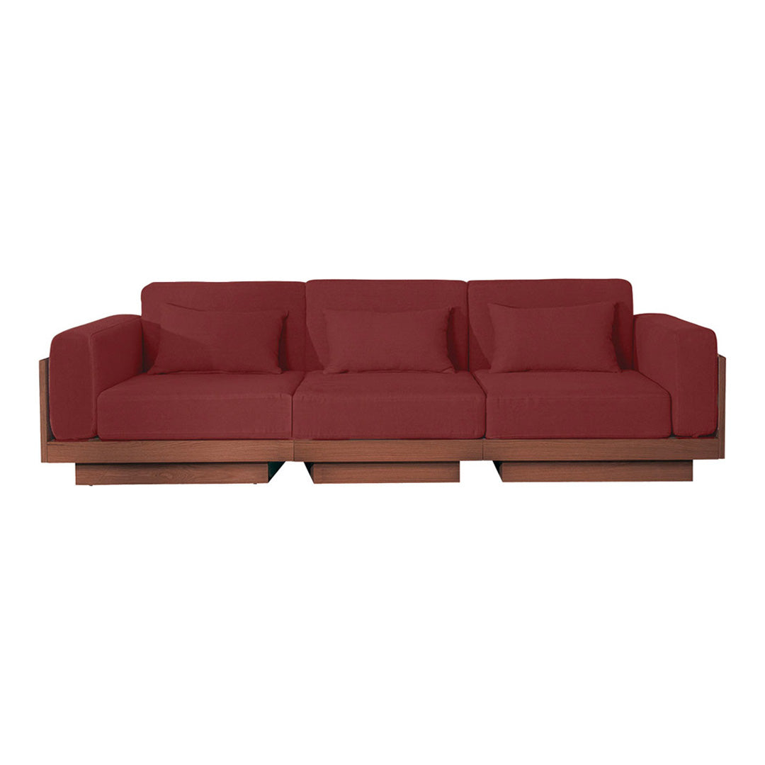 Stylish deep red sofa with plush cushions and smooth wooden base, perfect for modern living spaces.