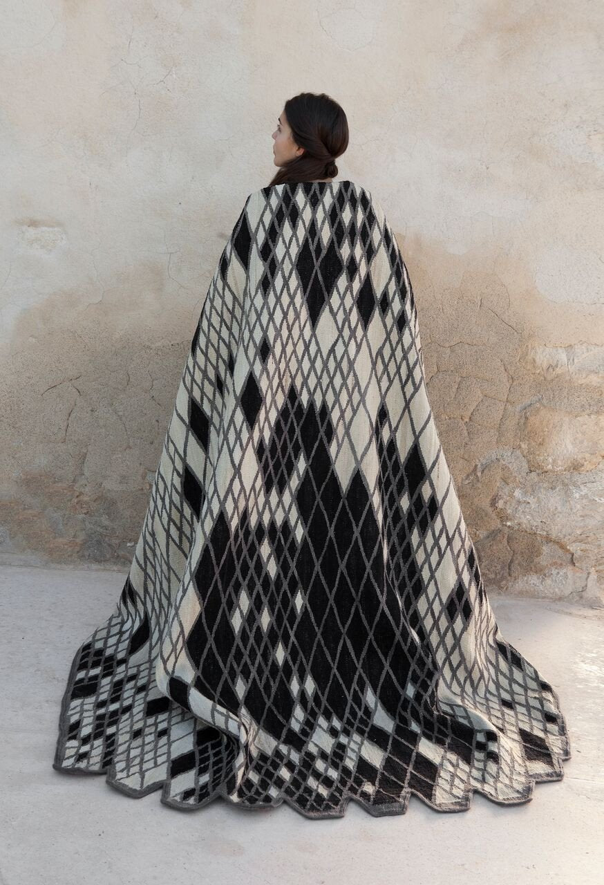 Black and white geometric diamond pattern throw blanket, featuring a bold checkered design and soft texture.