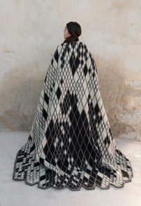 Black and white geometric diamond pattern throw blanket, featuring a bold checkered design and soft texture.