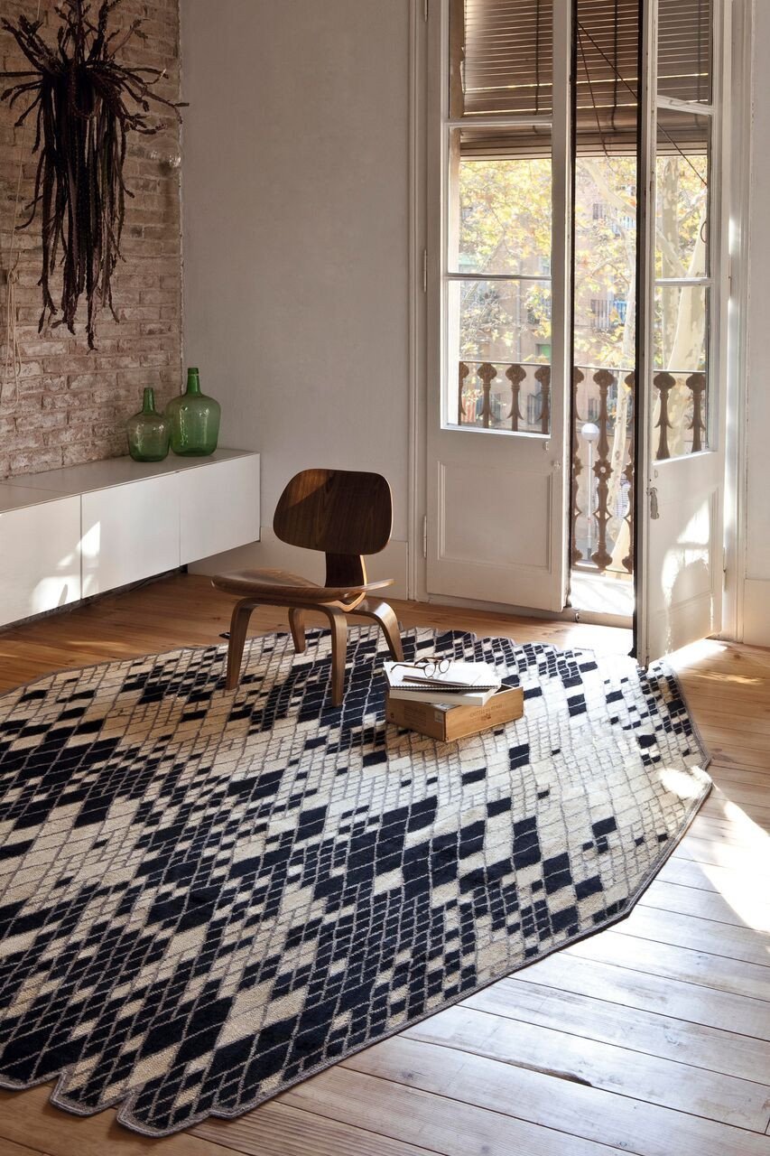 Textured rug featuring a geometric black and white pattern, perfect for modern interiors.