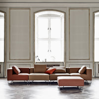 Modern sectional sofa with warm brown and rust hues, featuring a sleek, minimalist design and soft upholstery.