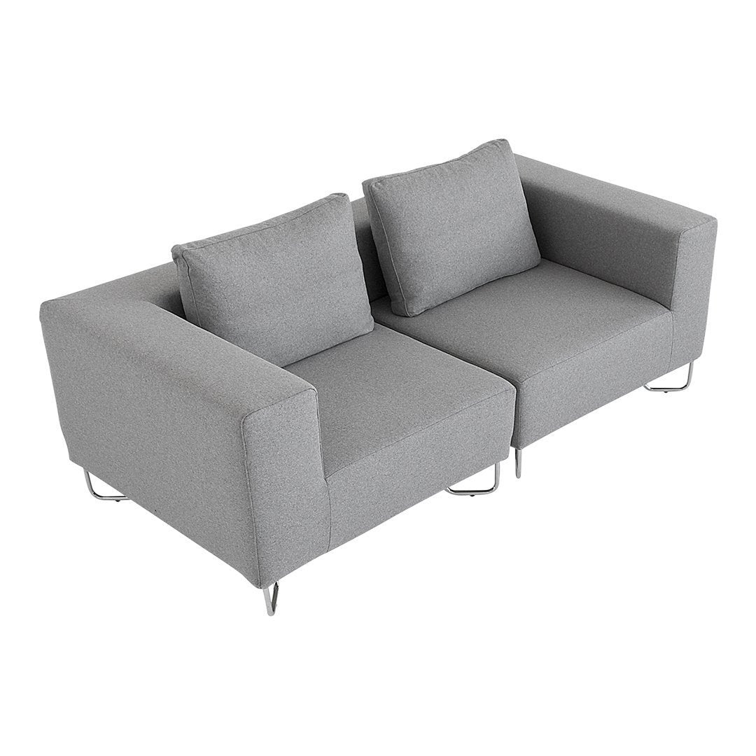 Gray upholstered loveseat with clean lines and soft cushions, featuring a modern minimalist design.
