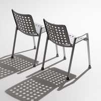 Gray chairs with polka dot patterns casting intricate shadows on a light background. Ideal for modern decor.