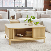 Natural wood coffee table with light oak finish and subtle ribbed pattern, featured in a cozy, neutral-toned living space.