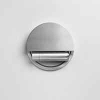 Sleek stainless steel round wall-mounted toilet paper holder with a minimalistic design and smooth finish.