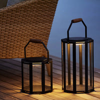 Black metal lanterns with glass panels and wooden handles, featuring a sleek geometric design, ideal for outdoor decor.