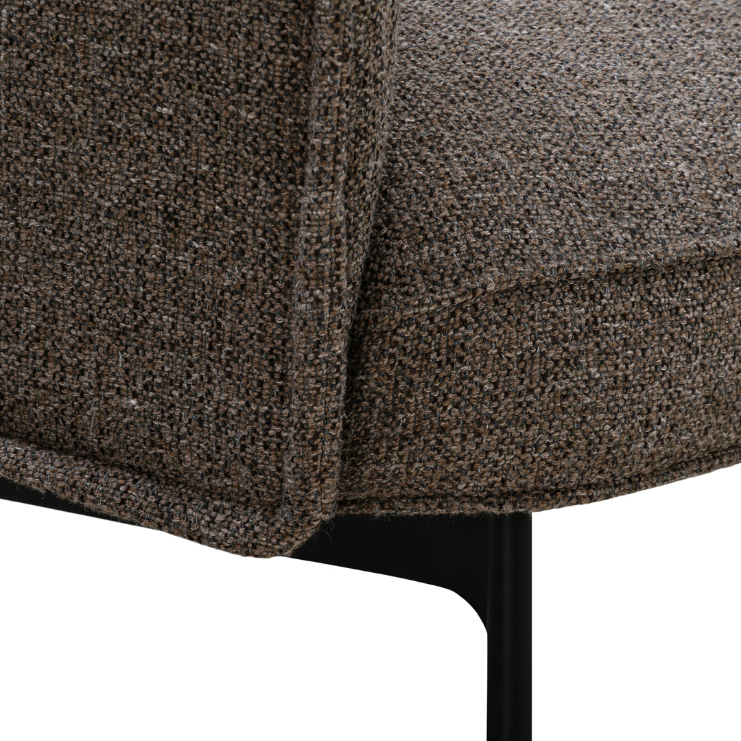 Brown textured fabric detail with subtle gray flecks on a modern chair, featuring a sleek black metal base.