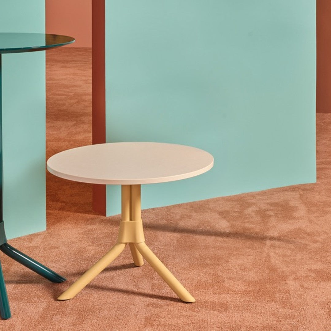 Stylish round tables in cream and teal against peach and aqua backgrounds, featuring modern minimalistic designs.