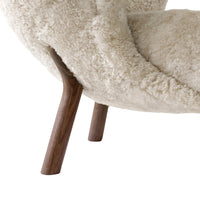 Cream plush chair with a textured surface and wooden legs in a rich walnut finish.