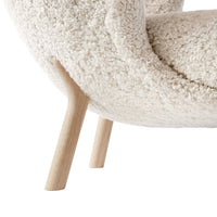 Cream textured upholstery with soft, fluffy pattern and light wooden legs for a modern, cozy look.