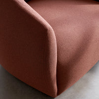 Textured rust-colored upholstery showcasing a smooth, curved design. Perfect for modern decor.