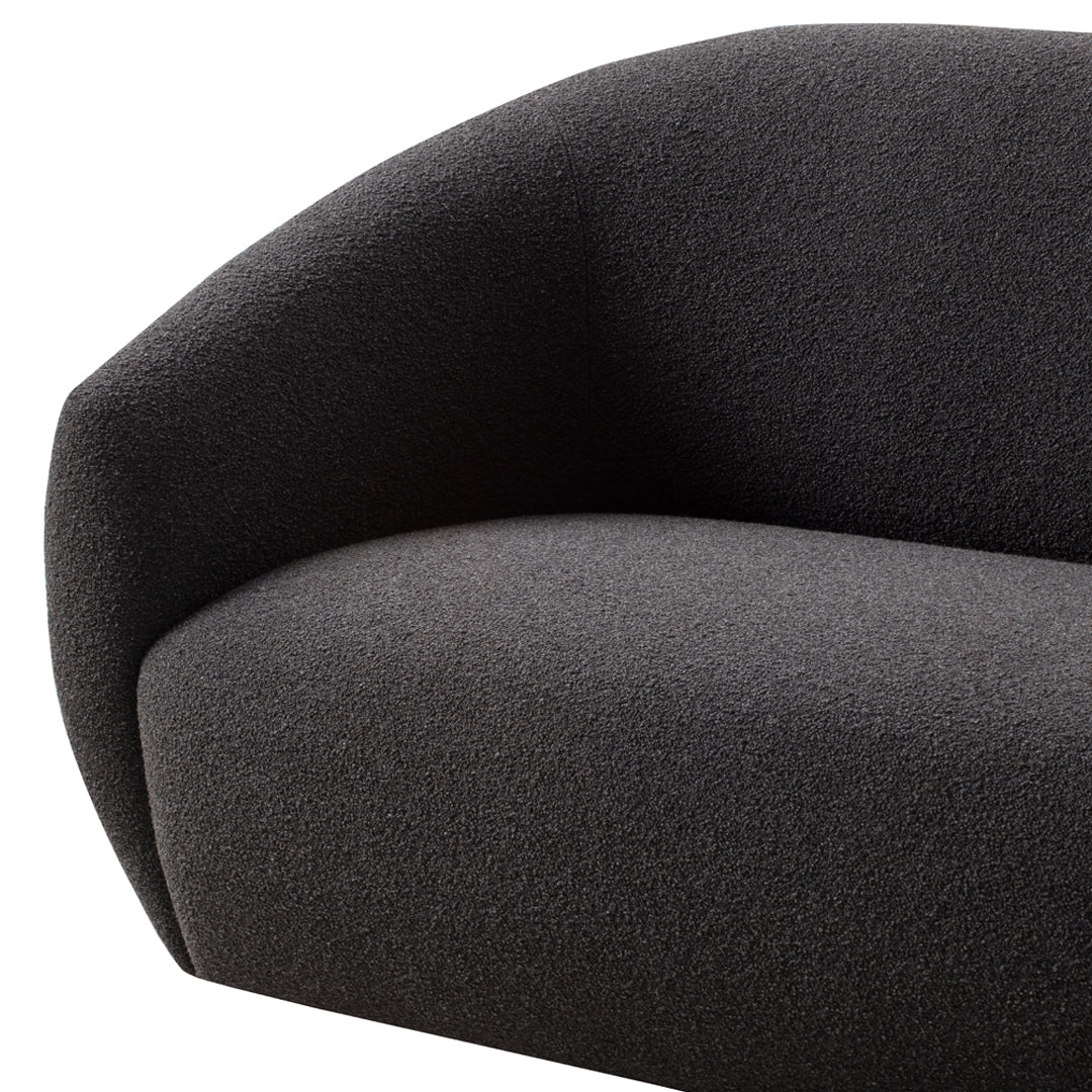 Curved black sofa featuring a textured, deep charcoal upholstery for a modern, minimalist aesthetic.